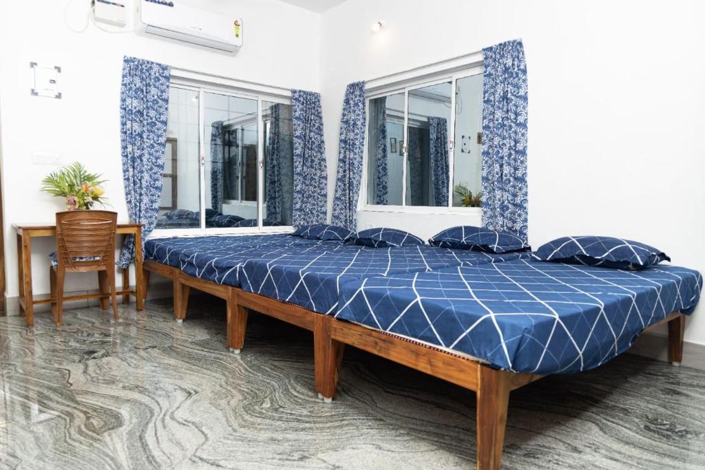 a bedroom with a large bed with a blue comforter at BrightMoon_Homestay in Puducherry