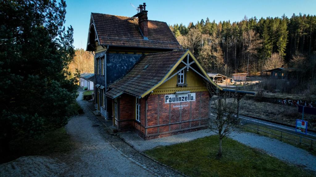a small building with a sign on the side of it at Bahnhof Paulinzella mit Sauna in Königsee