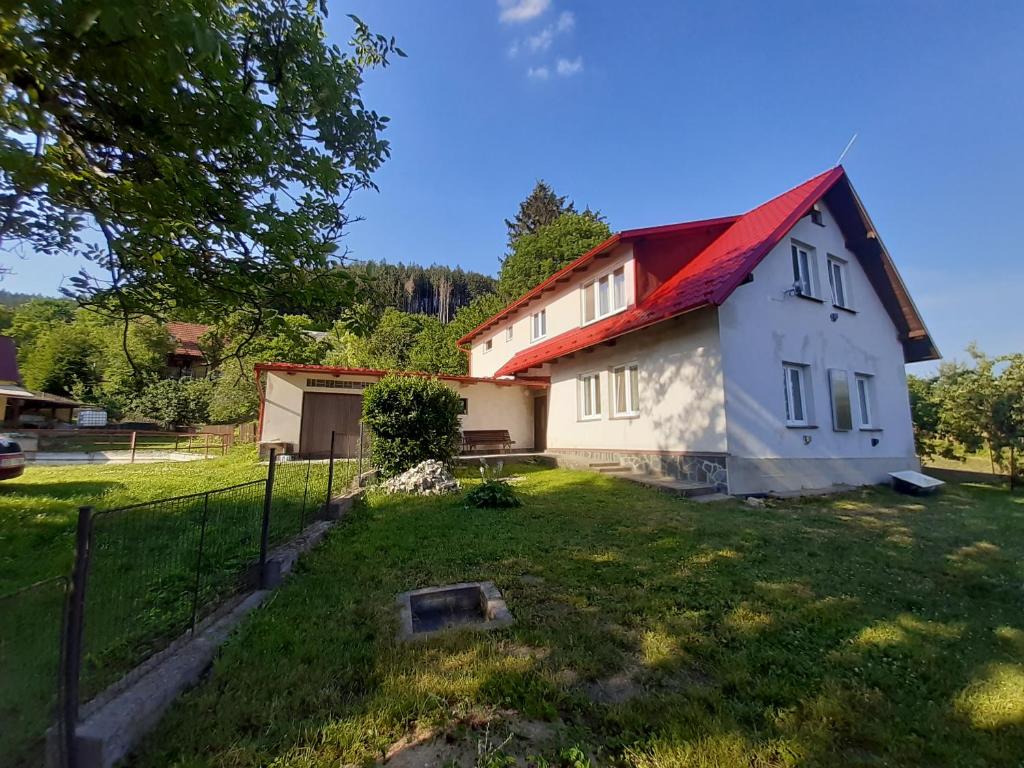 una casa con techo rojo en un patio en Chalupa u rybníka, Dobrá Voda, en Dobrá Voda