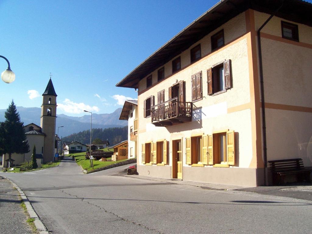 a building with a balcony and a clock tower at Casa Iride in Canale San Bovo