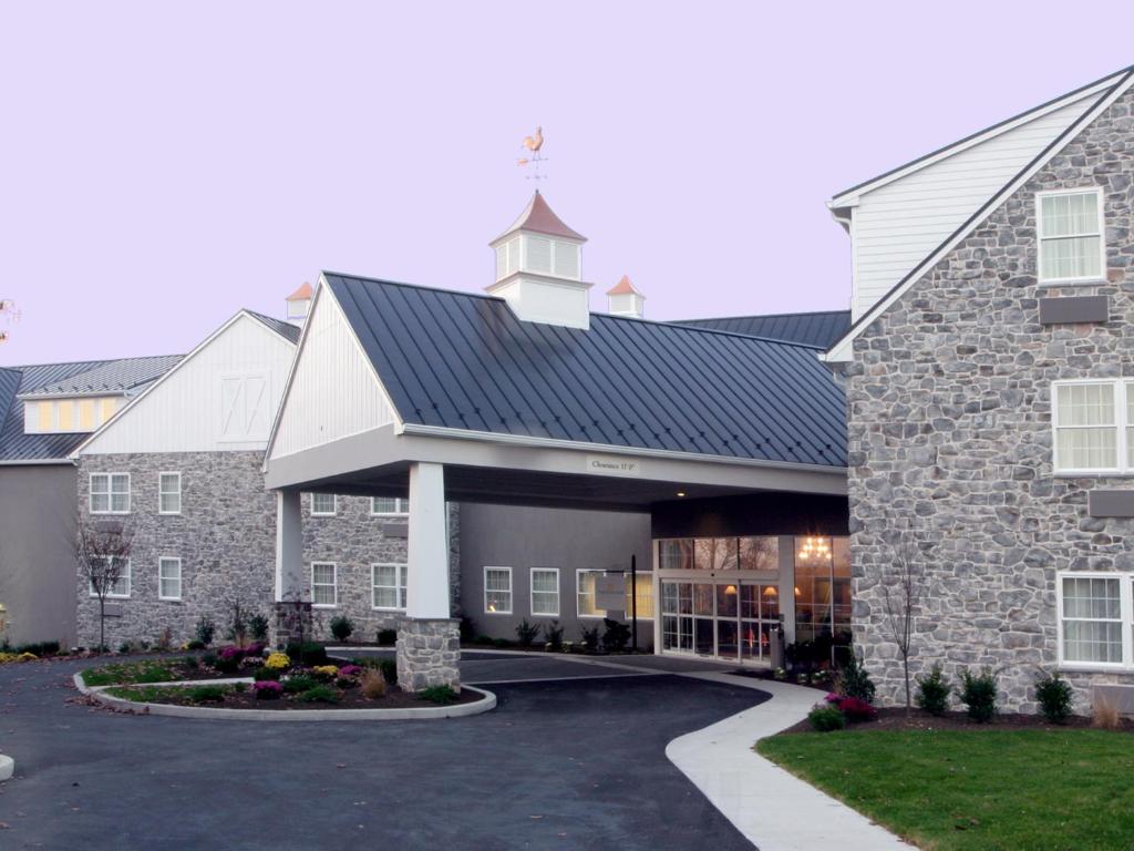 a large stone building with a clock tower on top at Amish View Inn & Suites in Bird-in-Hand
