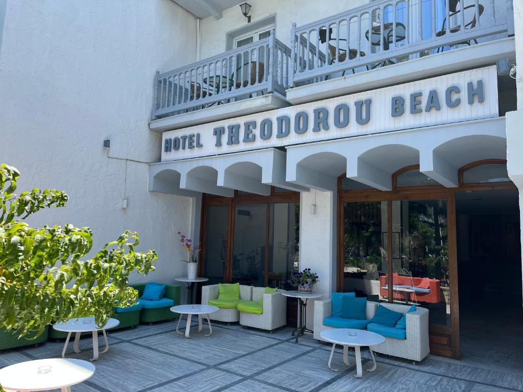 a hotel with chairs and tables in front of a building at Theodorou Beach Hotel Apartments in Kos