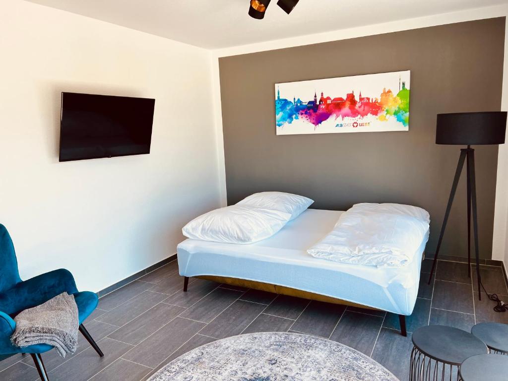 um pequeno quarto com uma cama e uma televisão em Living797 em Albstadt