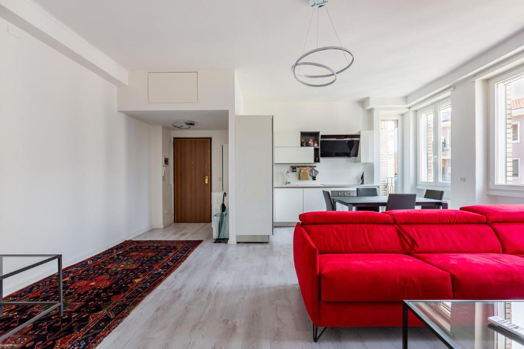 a living room with a red couch and a table at Garibaldi & Gae Aulenti Modern Apt with Private Parking! in Milan