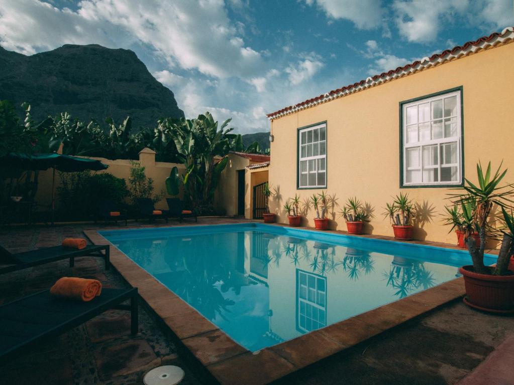 a swimming pool in front of a house at Hotel Rural La Casa Amarilla in Los Silos