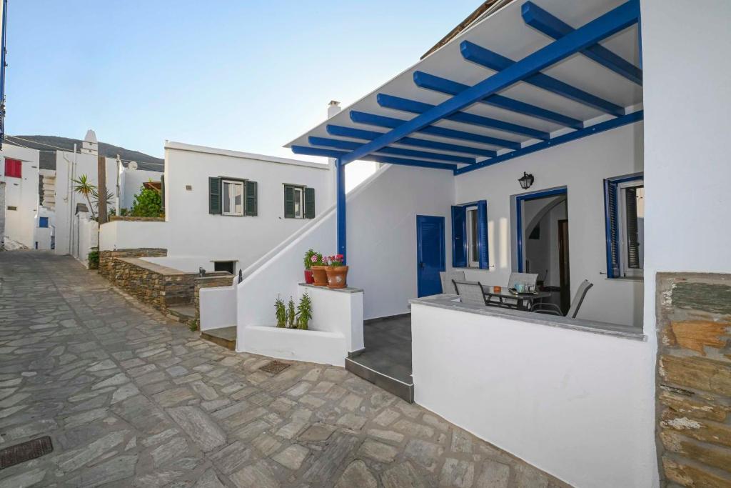 Biały dom z niebieskim dachem w obiekcie Η όμορφη Κώμη - Beautiful Komi spacious apartment w mieście Kómi