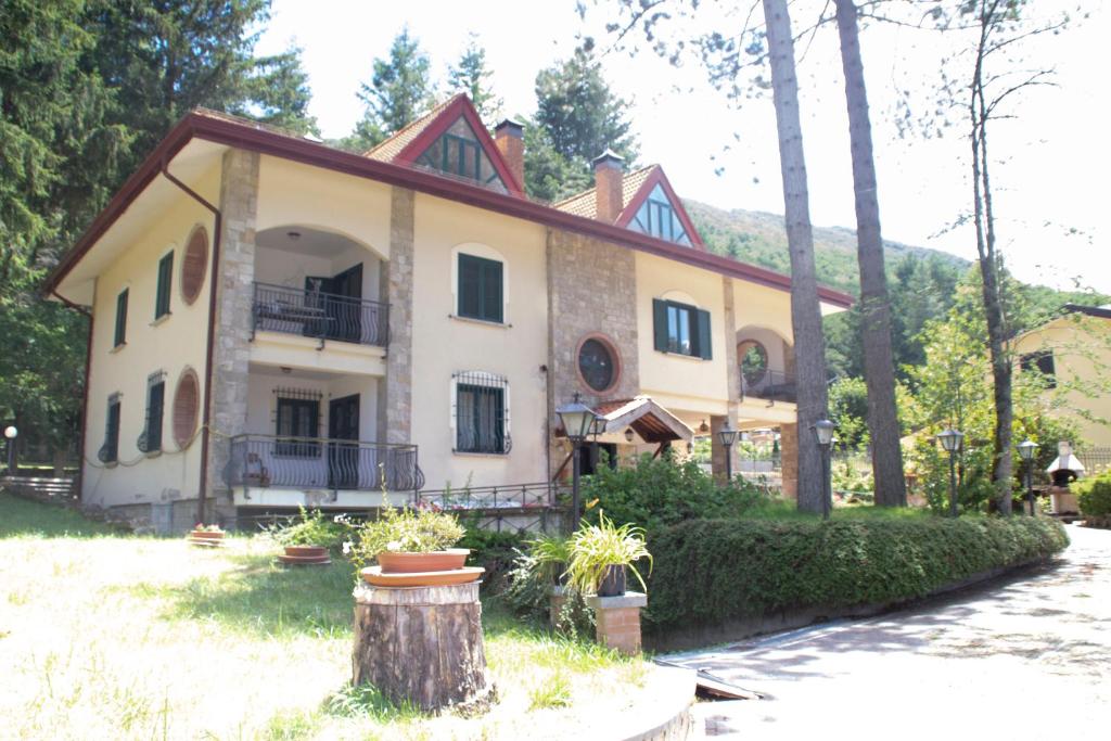 una casa con un tronco de árbol delante de ella en Casa Tronola en Villaggio Laceno