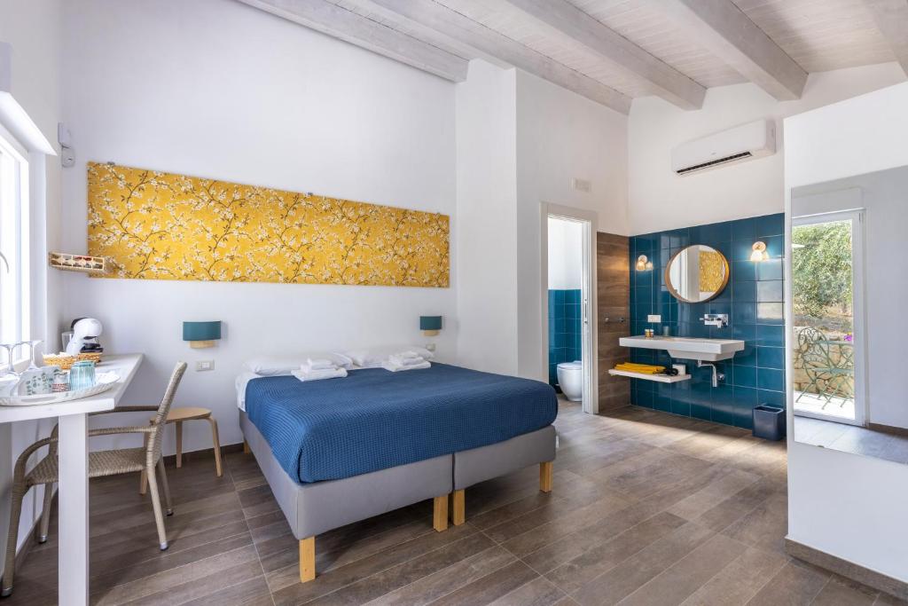 a bedroom with a blue bed and a bathroom at I Gelsomini Guest House in Noto
