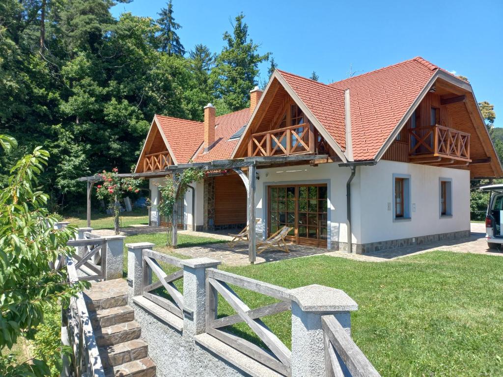 una casa con techo de madera y valla en Apartmaji Pri Handelčanih, Zreče, en Zreče