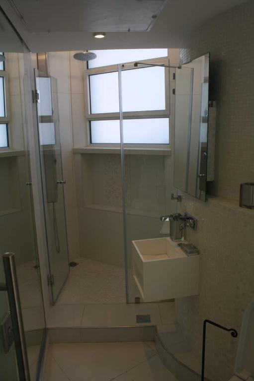 a bathroom with a shower and a sink and a window at The White House Jerusalem סוויטת הבית הלבן ירושלים in Jerusalem