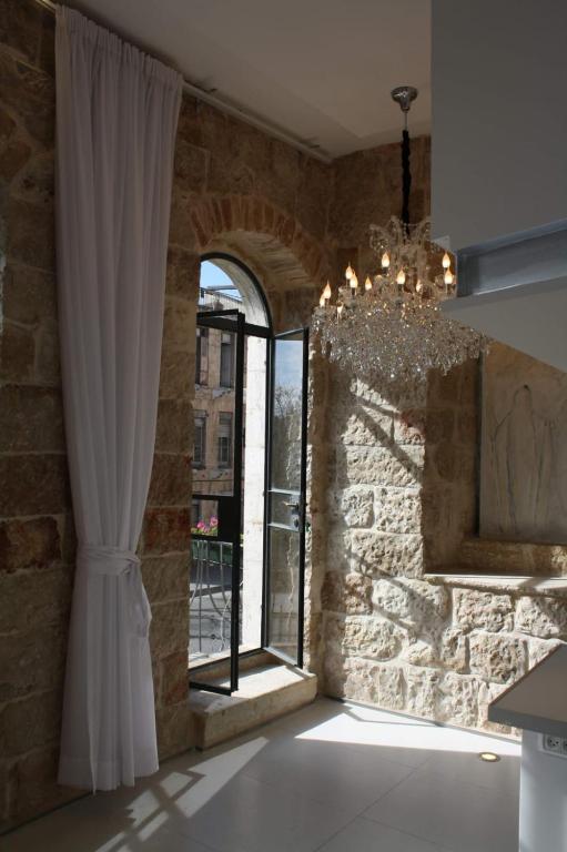 a room with a large window and a chandelier at The White House Jerusalem סוויטת הבית הלבן ירושלים in Jerusalem