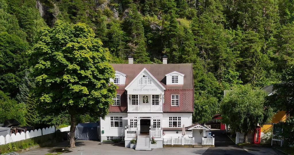 Valldal Fjord Lodge B&B في فالدال: بيت كبير ابيض واحمر امام جبل