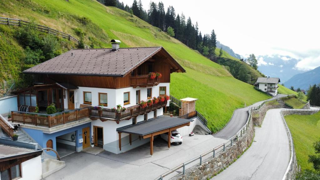 una pequeña casa en una colina al lado de una carretera en Appartement Gsaller, en Hopfgarten in Defereggen