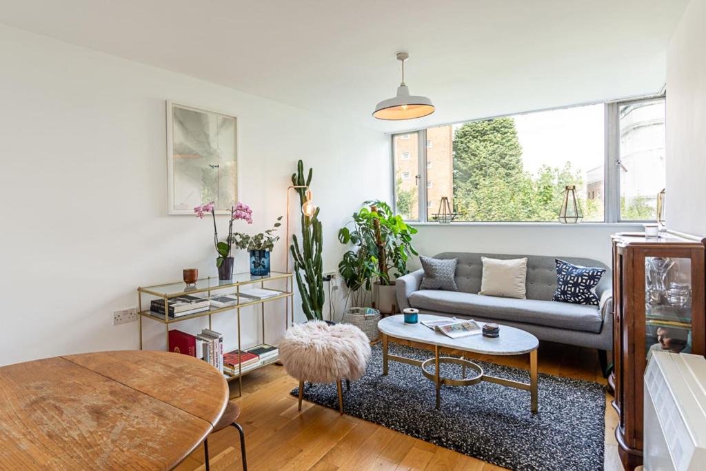 a living room with a couch and a table at Modern Victoria Park Apartment in London