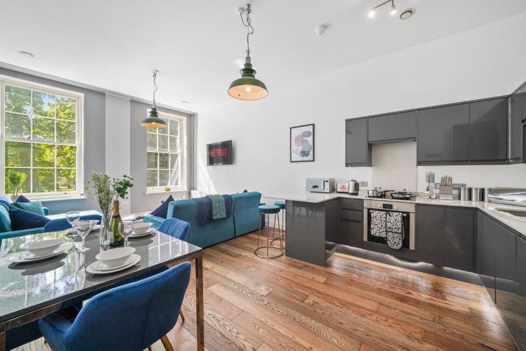 a kitchen and living room with a table and blue chairs at Stunning Abode - Sleeps 10 - Parking in Bristol