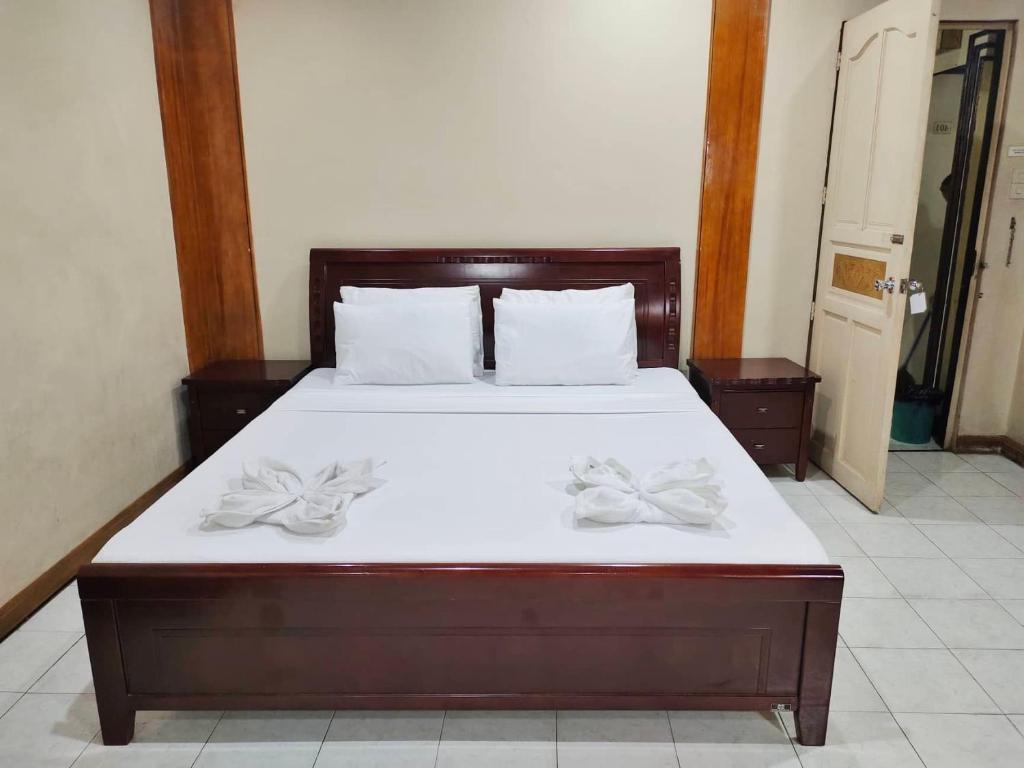 a bedroom with a large bed with white sheets and two bows at Parkview Hotel in Cagayan de Oro