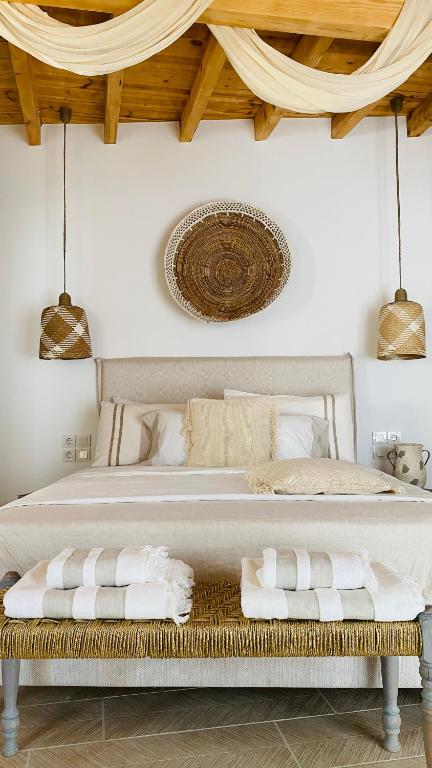 una camera da letto con un grande letto bianco con asciugamani su una panca di Linari Bohemian Living a Kávallos