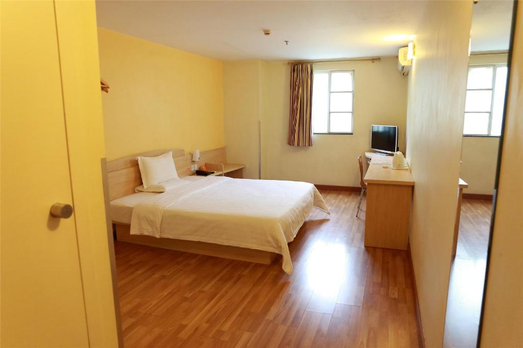 a bedroom with a bed and a desk and a television at 7Days Premium Xiamen University South Siming Road in Xiamen