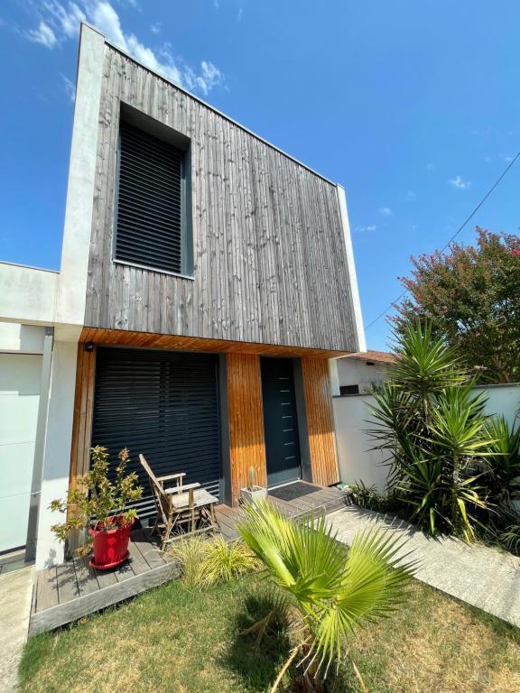 ein Haus mit Holzfassade und Terrasse in der Unterkunft Maison Candau in Pessac