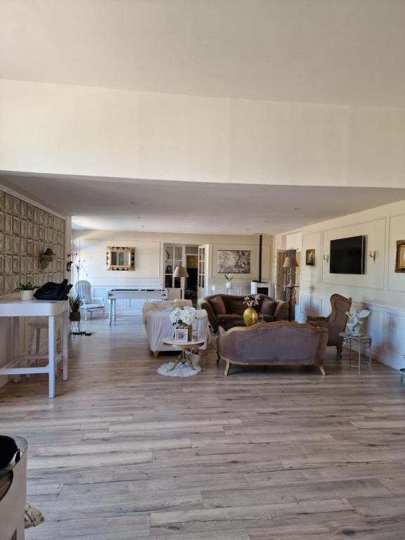 een grote woonkamer met banken en een woonkamer met een tafel bij Bâtisse XVIII ème, dans enceinte d'un château. in Brains-sur-Gée