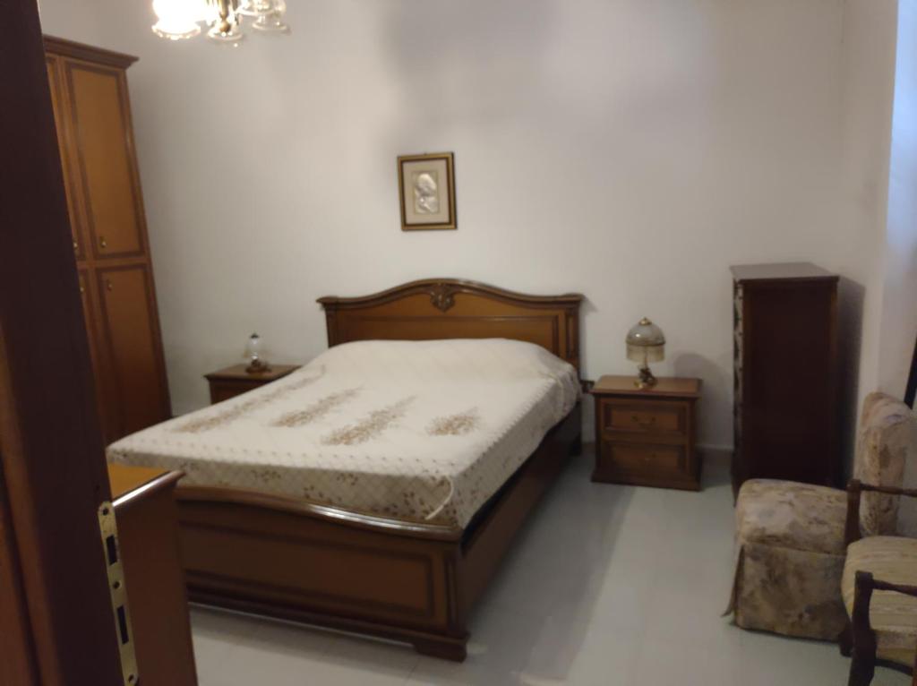 a bedroom with a bed and two tables and a chair at MC in Gonnesa