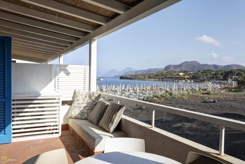 balcone con divano e vista sull'oceano di Les Sables Noirs & Spa- appartamento multiproprietà a Vulcano