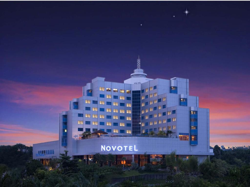 un hôtel novotel est éclairé la nuit dans l'établissement Novotel Balikpapan, à Balikpapan