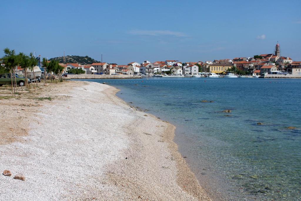 a view of a beach with houses and the water at Apartments with a parking space Betina, Murter - 17478 in Betina