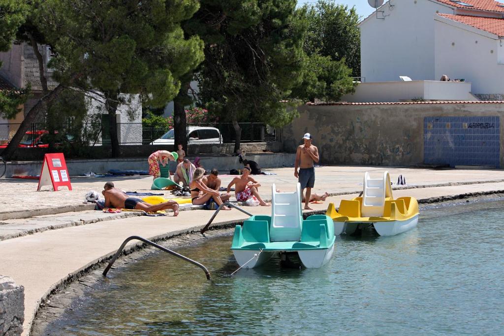 a group of people laying in the water with boats at Apartments with a parking space Betina, Murter - 17478 in Betina