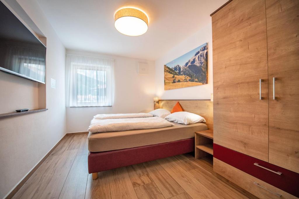 sypialnia z łóżkiem i dużą drewnianą szafką w obiekcie Apartments Cesa Ploner w mieście Ortisei