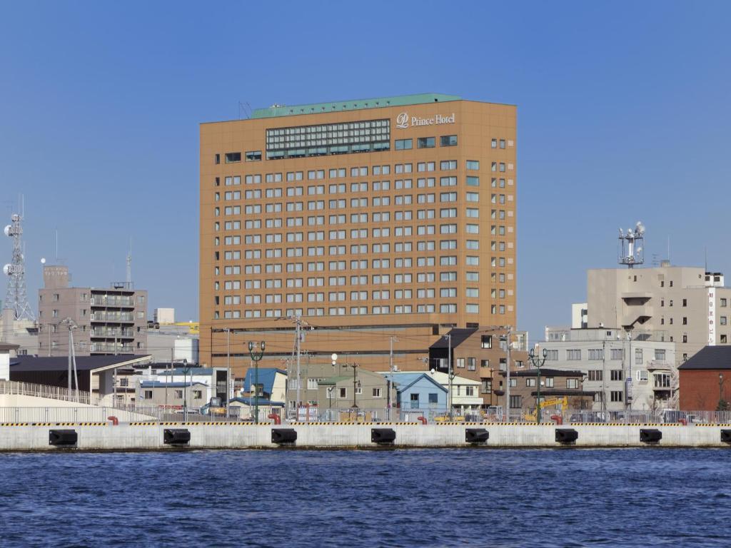 um grande edifício em uma cidade ao lado de um corpo de água em Kushiro Prince Hotel em Kushiro