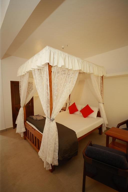 a bedroom with a bed with a canopy at Ayla Homes in Madikeri