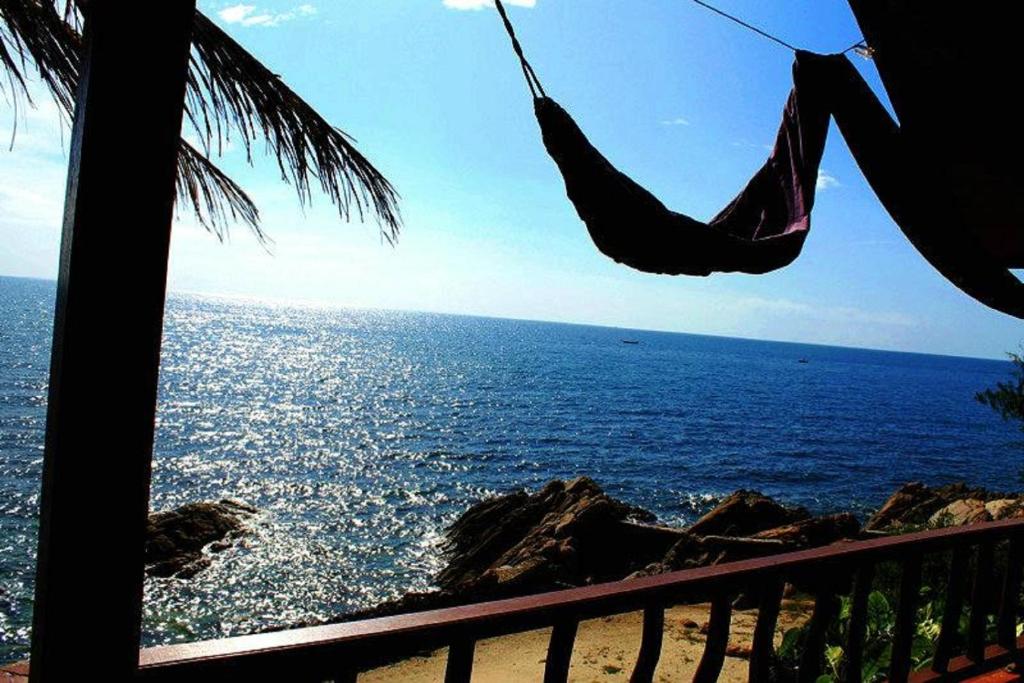 a hammock hanging in front of the ocean at Lucky Resort in Haad Yao
