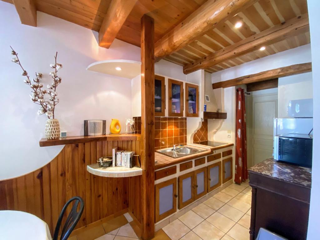 a kitchen with wooden cabinets and a counter top at Appartement 4 pers plein centre ville, wifi, balcon in Laragne