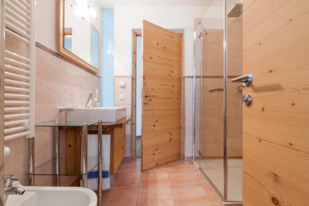ein Bad mit einem Waschbecken und einer Dusche in der Unterkunft Apartments Mirandula in St. Ulrich in Gröden