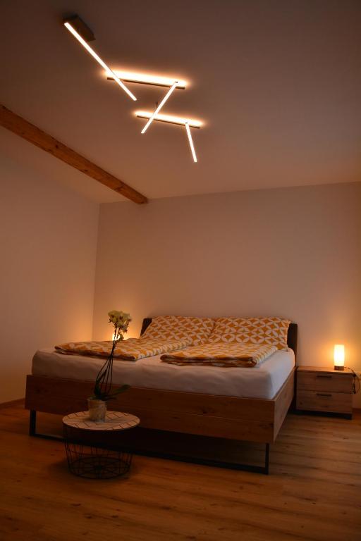 a bedroom with a bed and a light on the ceiling at Wachtelwerkstatt in Unternalb