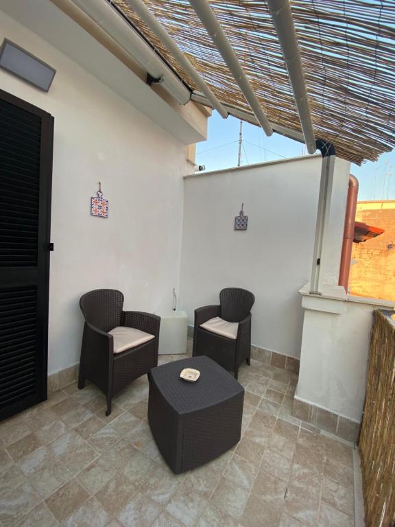 um pátio com cadeiras, uma mesa e uma janela em Elly’s House em Bari
