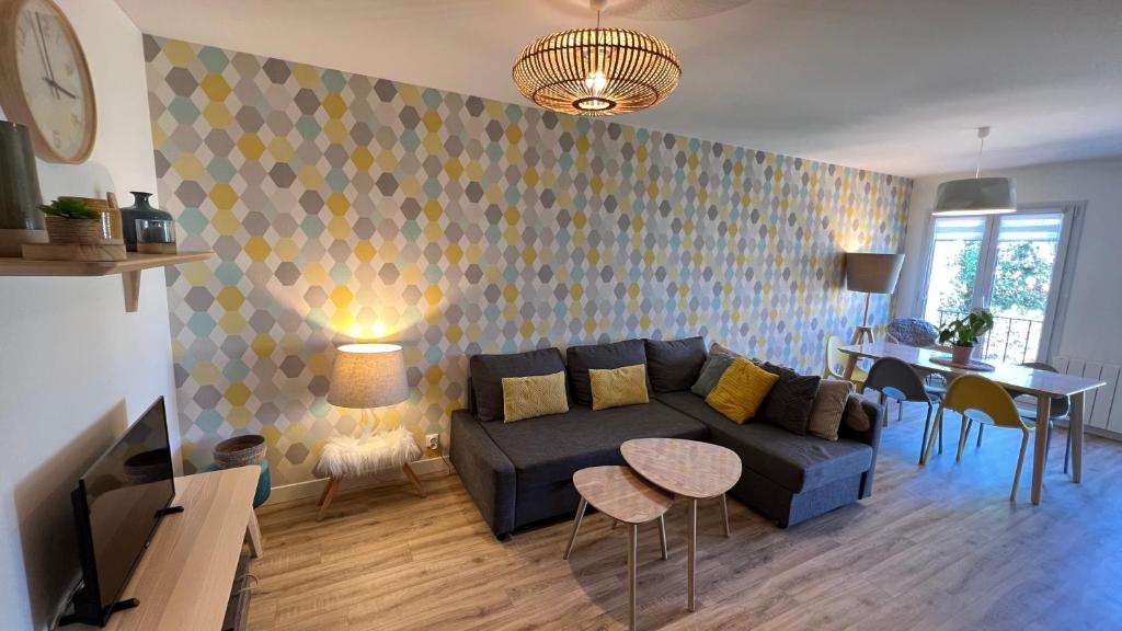 een woonkamer met een blauwe bank en een tafel bij Côté lac in Gérardmer