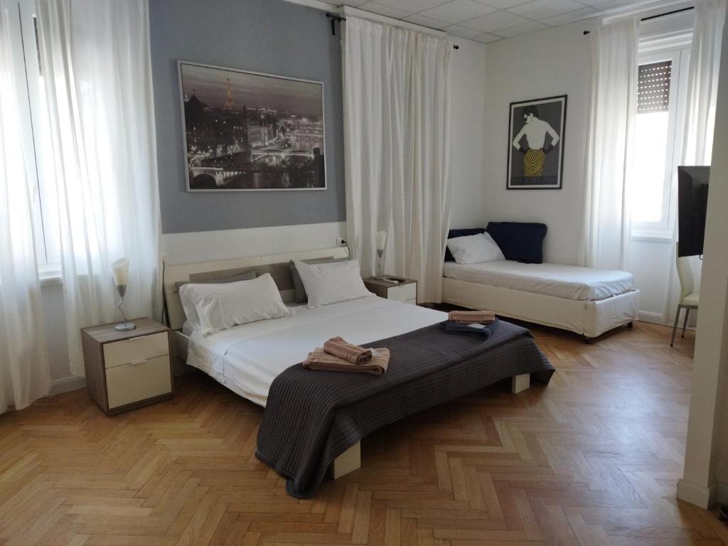 a bedroom with a bed and a couch in it at Piazza Goldoni Rooms in Trieste