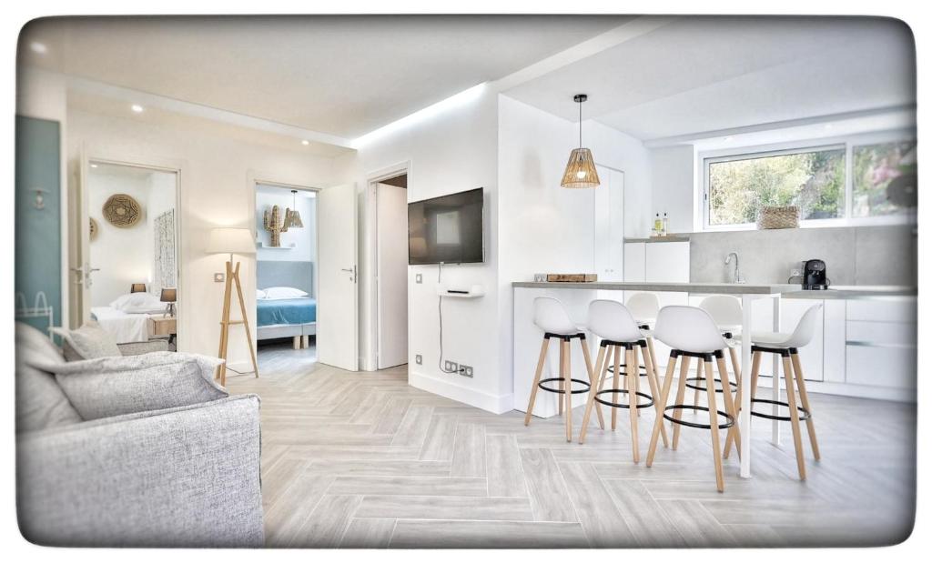 a living room with a kitchen and bar with stools at Le Vallaya Suites & Spa in Menton