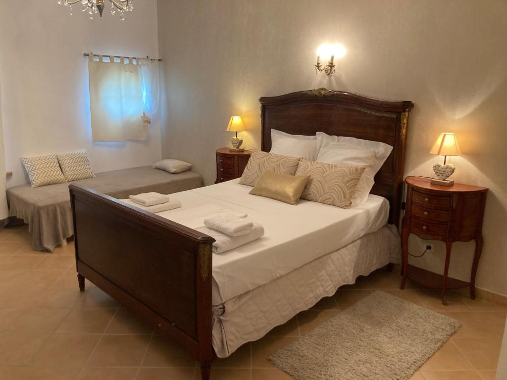 una camera da letto con un grande letto con lenzuola e cuscini bianchi di La porte dorée... a Saint-Nicolas-de-la-Grave