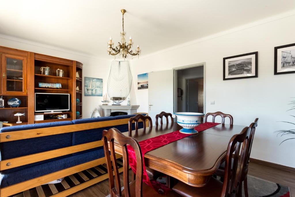 uma sala de jantar com uma mesa de madeira e cadeiras em Casa do Faria em Caminha