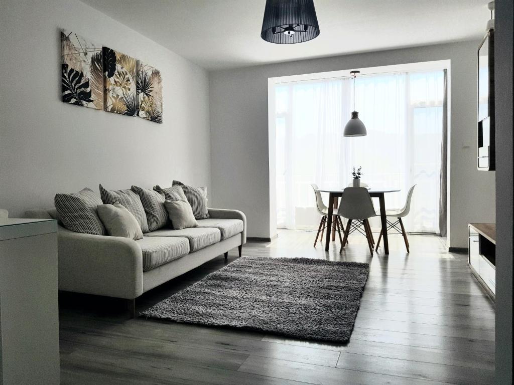 a living room with a couch and a table at Alexa Apartament in Târgu-Mureş