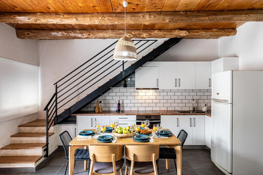 a kitchen with a table and chairs and a staircase at G&M House in Kefalás