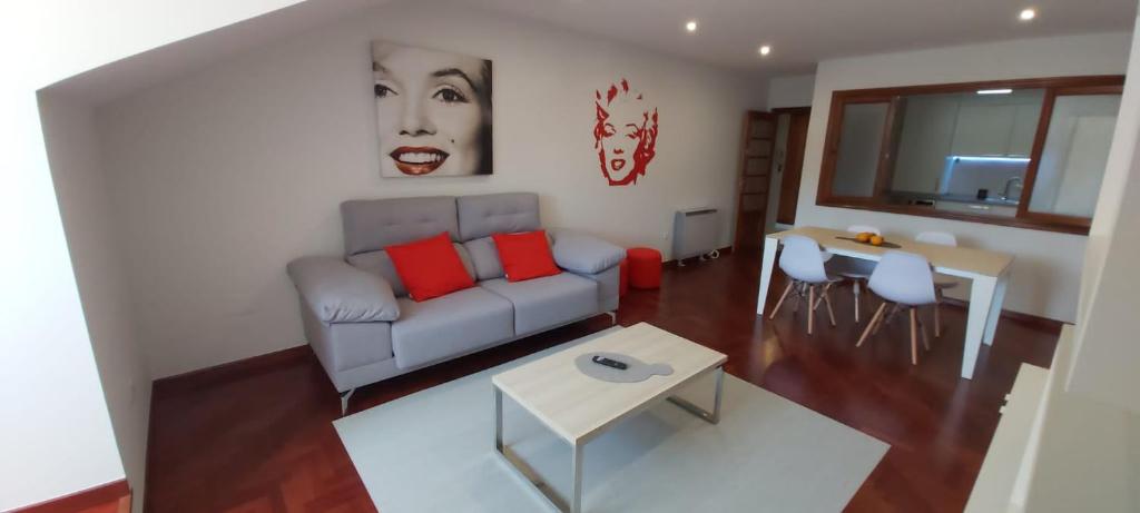 uma sala de estar com um sofá e uma mesa em Apartamentos LEON XIII em Vilagarcía de Arousa