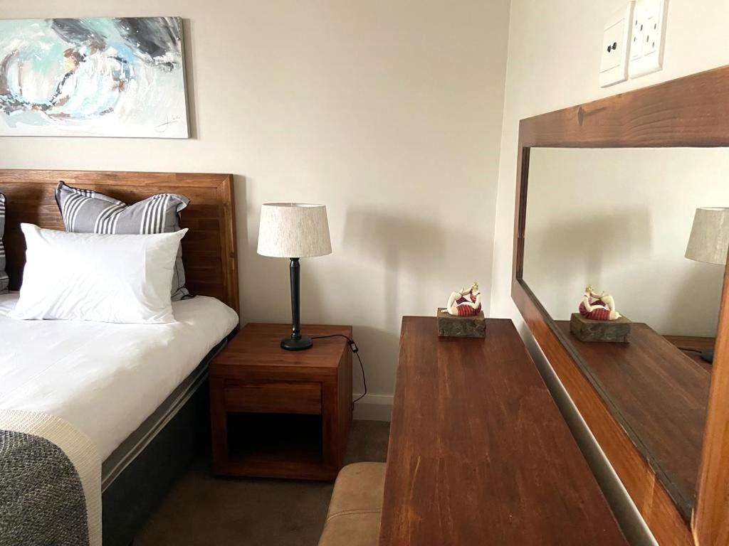 a hotel room with a bed and a mirror at Canal Quays 507 in Cape Town