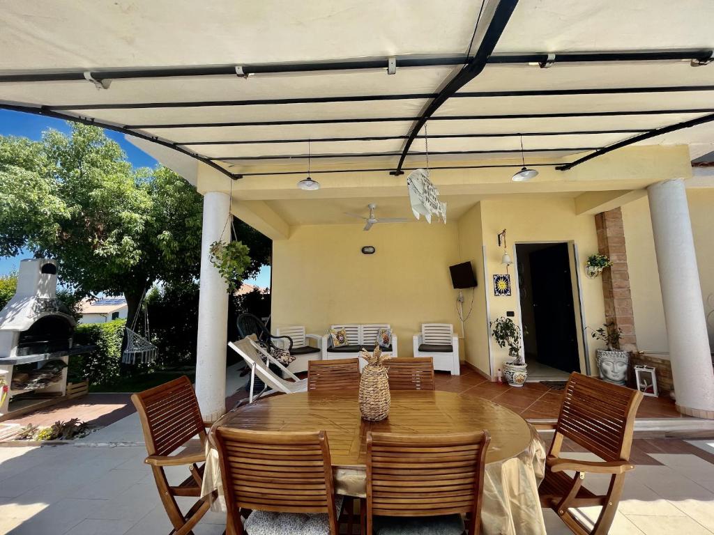 a patio with a wooden table and chairs at Villa Solemar in Briatico