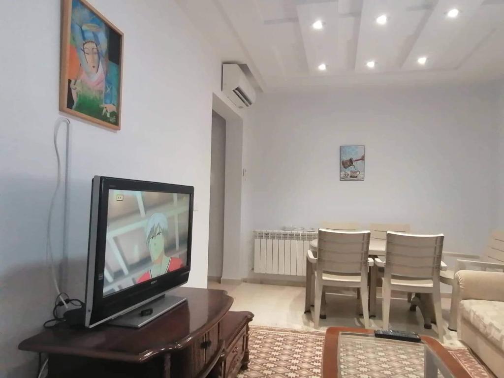 sala de estar con TV, mesa y sillas en Zayatine C7 en Sfax