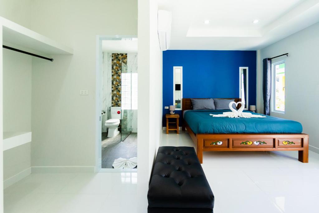 una camera da letto con pareti blu, un letto e un bagno di Coco Sea Bangpo Resort a Ban Bang Po