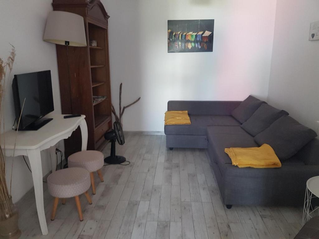 a living room with a blue couch and a desk at Appartement Ré (4 personnes) in Châtelaillon-Plage